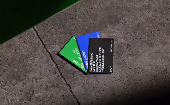 Green, blue and black business cards scattered on concrete