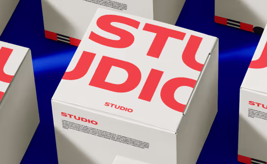 Shipping box printed with a large red Studio wordmark against blue