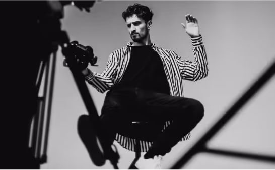 Black and white photograph of a dancer mid-movement on a striped set